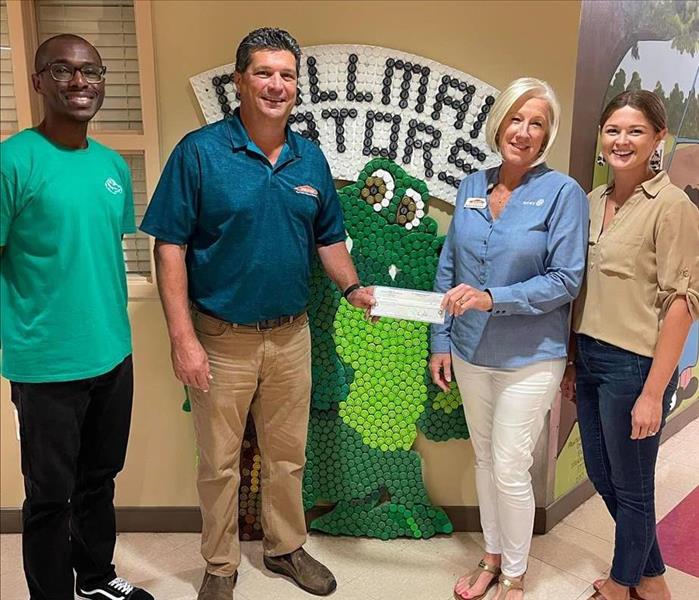 Owners Mel and Kimberly Kitchens presenting sponsorship for Gallman Elementary School 
