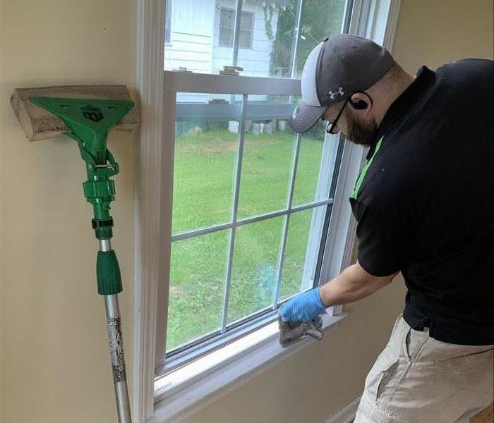 Our SERVPRO technician cleaning the window seals of Soot Damage from a house fire in Clinton, SC 