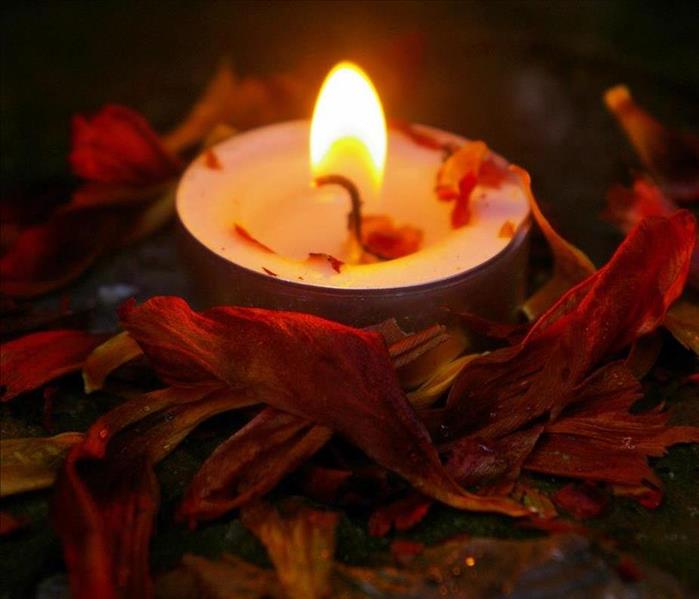 Candle Burning outside surrounded by leaves! 